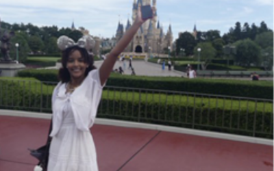 Sara stands in front of the Tokyo Disneyland castle