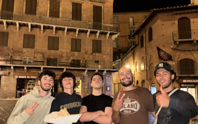 five people stand with a tall building behind them