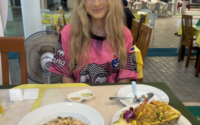 Madison sits at a table with two dishes in front of her