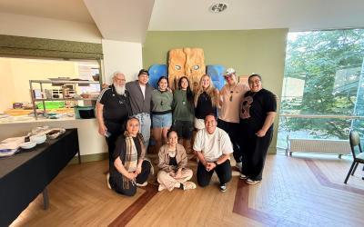 a group of 10 people stand together indoors