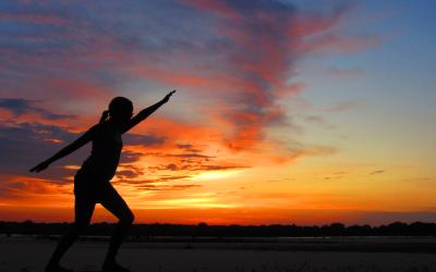 Person doing a yoga pose in front of a Tanzania sunset