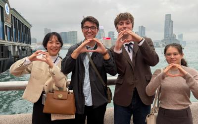 Kyler and three other students throwing their "O" on a cloudy day in Hong Kong, China.