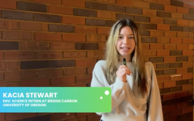 Kacia Stewart talking into a tiny mic in front of a brick wall in London