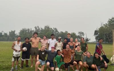 Cohort of GEO students playing soccer with locals on a foggy day in Nepal