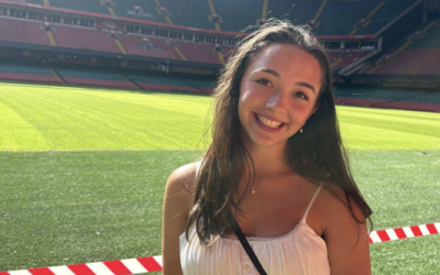 A uo student standing in front of a soccer field