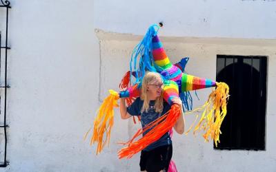 A uo student holding a piñata on the streets of Queretaro