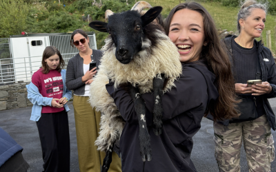 A uo student holding up a goat