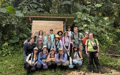 A group of UO students standing in front of a trail sign