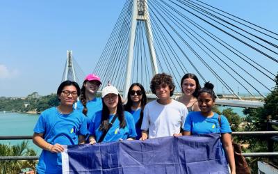 Group of Students holding a blue flag