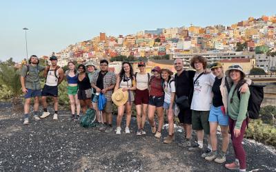 Group of UO students standing with a cityscape in the background