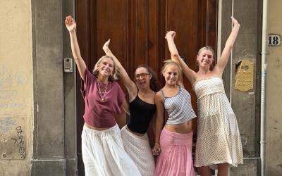 A group of UO students standing in front of a door with their hands in the air