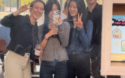 Four people standing in front of a mirror smiling