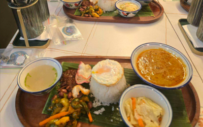 Two trays of food sitting on a white table