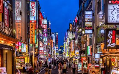 A bustling street in Tokyo with neon signs on buildings