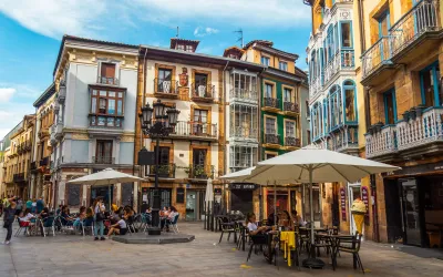 Colorful plaza in Oviedo where people are seated chatting and drinking tea